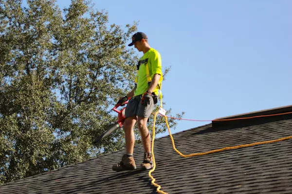 worker cleaning a roof